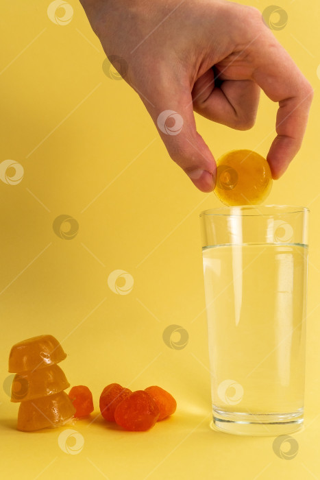 Скачать Растворимые напитки, растворяющие кубики для добавления суперпродуктов. На желтом фоне. Вертикальная фотография фотосток Ozero