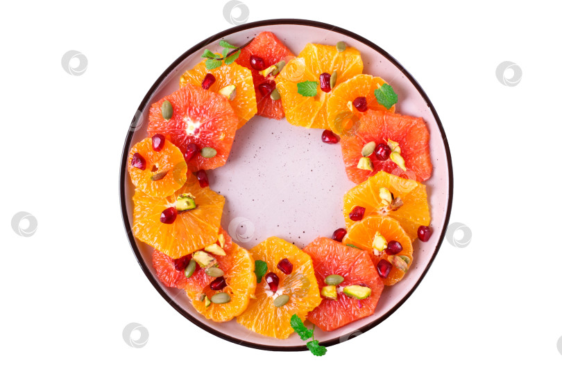 Скачать Салат из цитрусовых с дольками апельсина, кровавого апельсина и мандарина на круглой керамической тарелке, выделенной белым цветом. фотосток Ozero