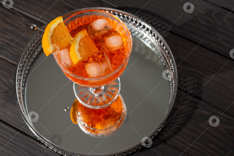 Скачать Коктейль Aperol Spritz в плоском бокале на зеркальном подносе фотосток Ozero