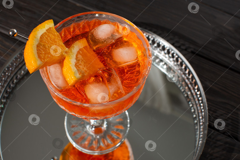 Скачать Коктейль Aperol Spritz в плоском бокале на зеркальном подносе фотосток Ozero