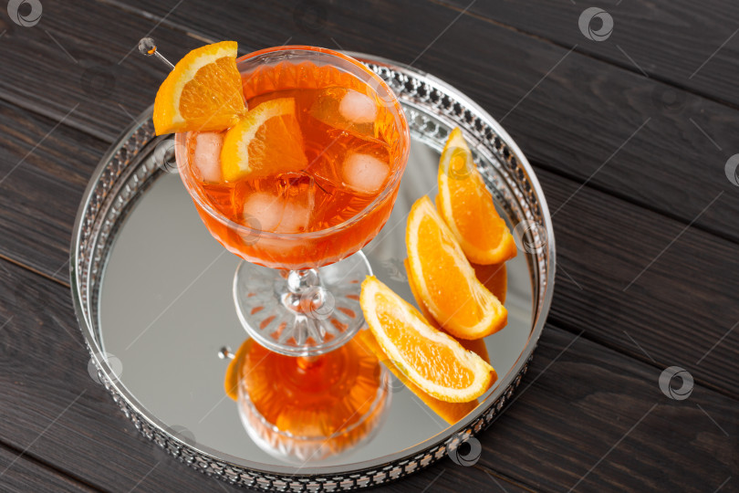 Скачать Коктейль Aperol Spritz в плоском бокале на зеркальном подносе фотосток Ozero