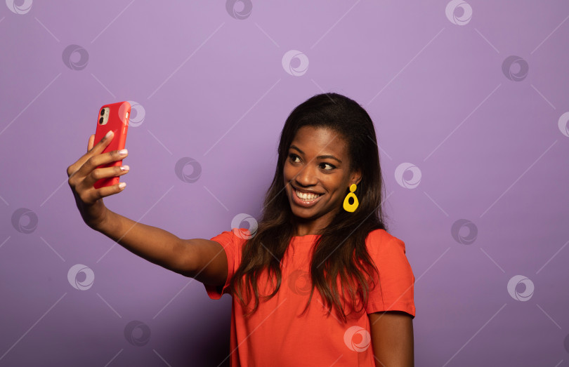 Скачать Портрет позитивной молодой афроамериканки, промоутера шоу смартфонов фотосток Ozero