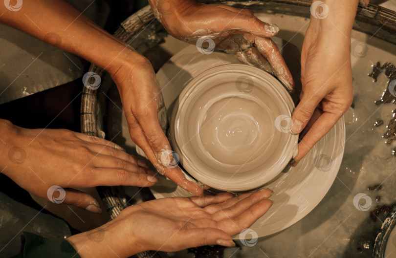 Скачать три женщины работают на гончарном круге, изготавливая вазу. фотосток Ozero