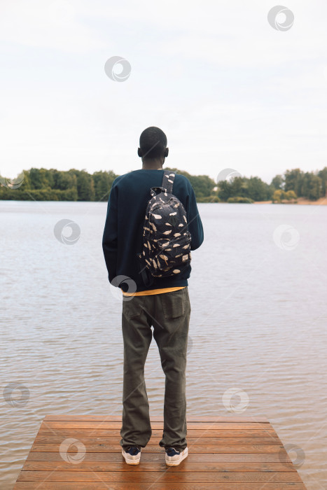 Скачать Молодой афроамериканец отдыхает в парке у озера. фотосток Ozero