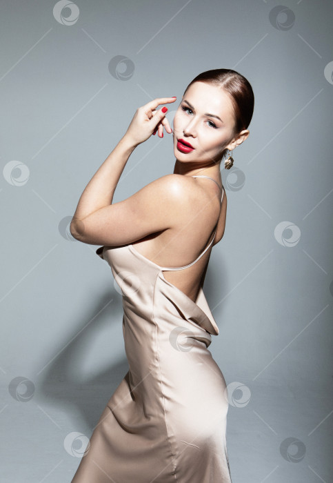 Скачать Портрет великолепной элегантной чувственной блондинки в модном платье, выделенный на сером фоне. фотосток Ozero