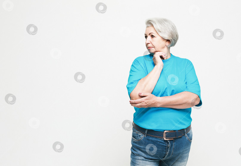 Скачать пожилые люди и концепция принятия решений - портрет пожилой женщины в синей футболке, размышляющей на белом фоне фотосток Ozero