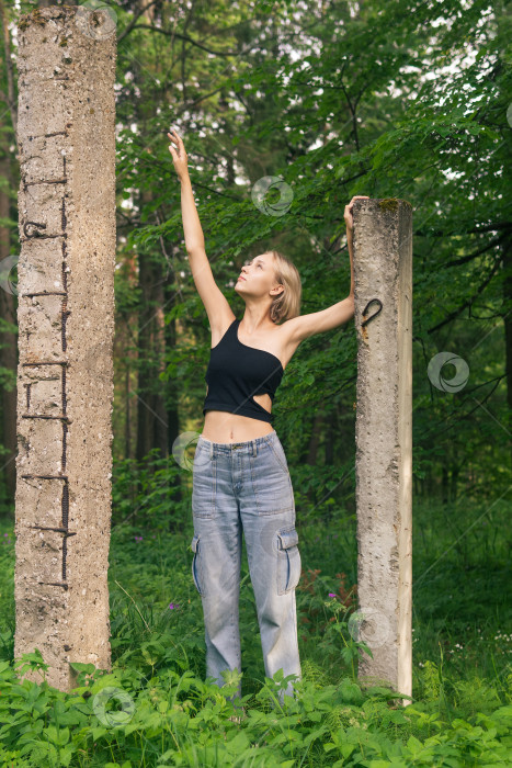 Скачать молодая женщина позирует рядом с бетонными сваями среди естественного ландшафта фотосток Ozero