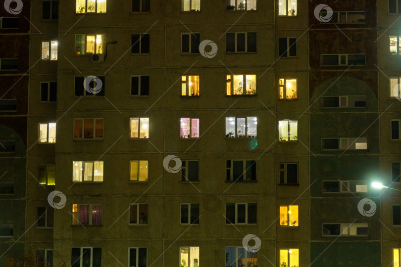 Скачать Окна многоэтажного дома, где у многих семей есть собственные квартиры. Ночное время фотосток Ozero