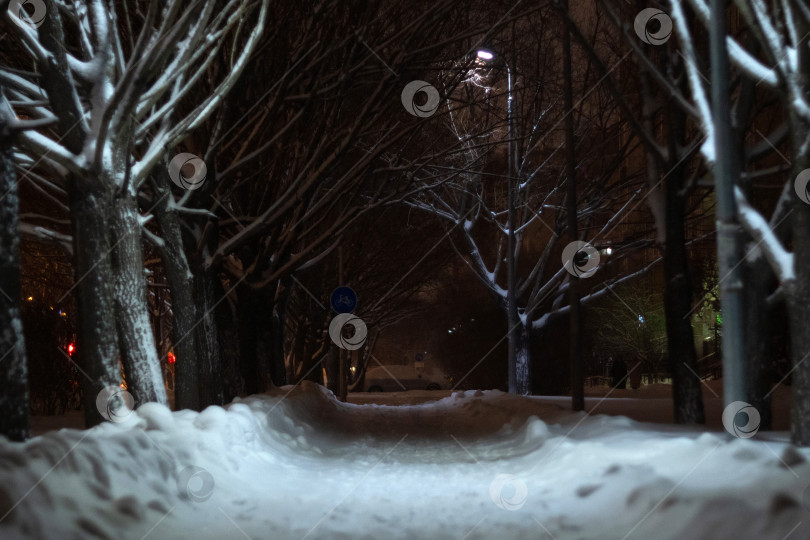 Скачать Заснеженная городская улица ночью, мирная атмосфера в снежную ночь. Избирательный фокус фотосток Ozero