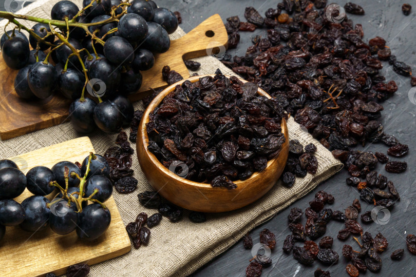 Скачать Сушеный черный изюм в миске со свежим органическим виноградом. Популярные продукты для приготовления или употребления в пищу. Избирательный фокус фотосток Ozero