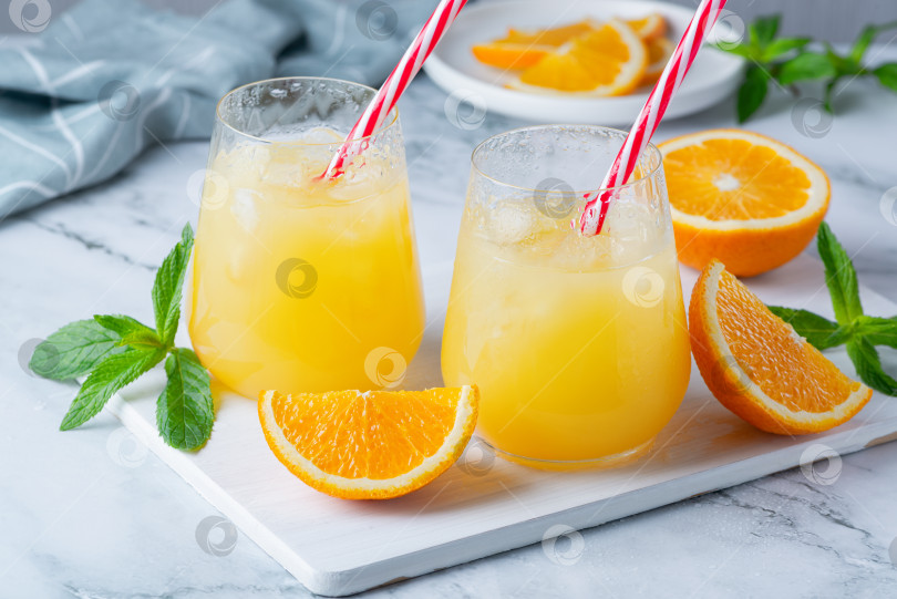 Скачать Стакан апельсинового сока со льдом. Холодный апельсиновый фреш. Бокал оранского фотосток Ozero