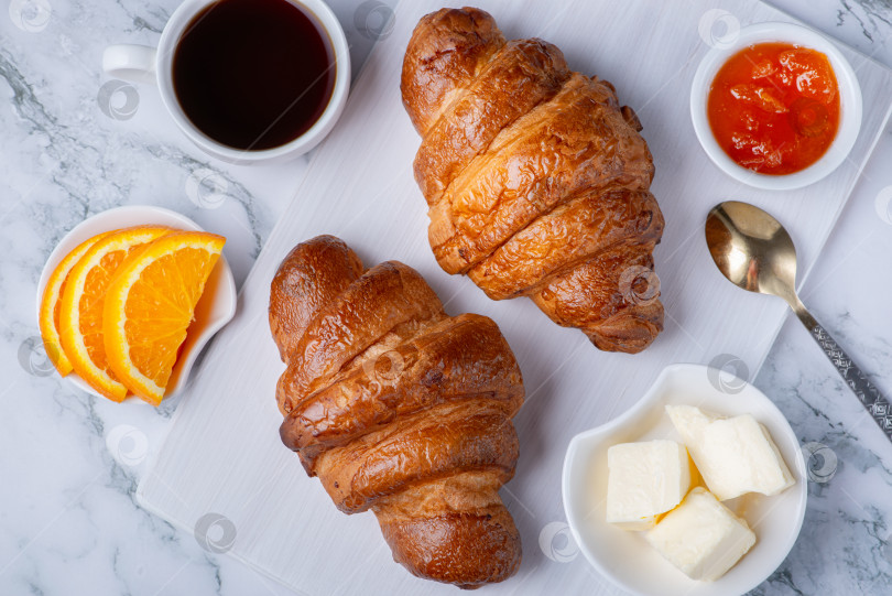 Скачать Свежие сладкие круассаны с маслом и абрикосовым джемом на завтрак фотосток Ozero