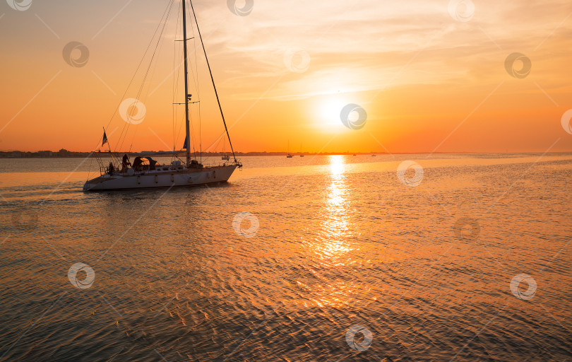 Скачать Яхта подплывает к пирсу. Время захода солнца на море фотосток Ozero