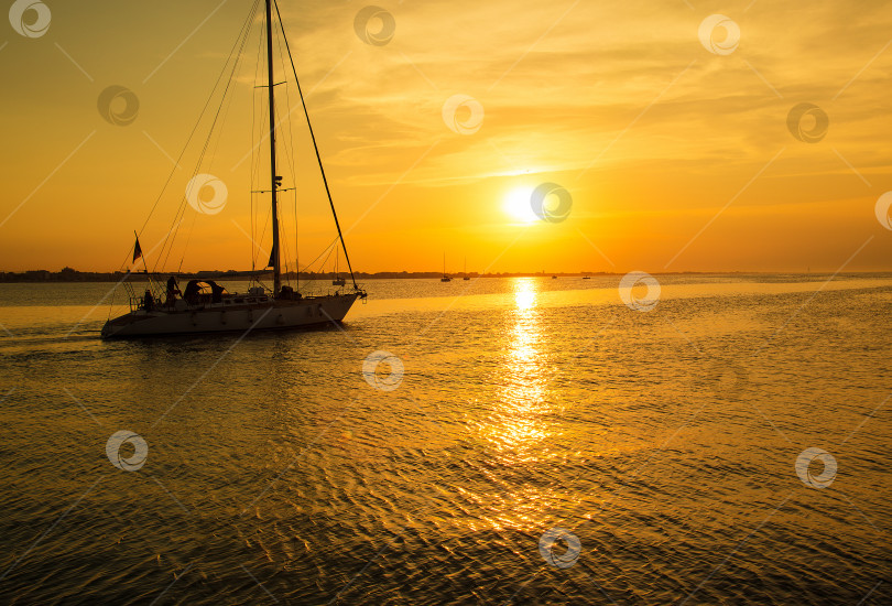 Скачать Яхта подплывает к пирсу. Время захода солнца на море фотосток Ozero