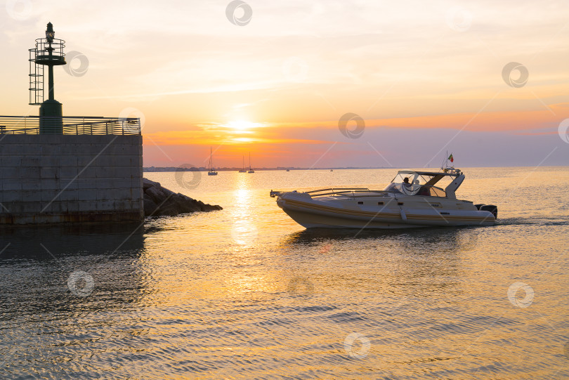 Скачать Яхта подплывает к пирсу. Время захода солнца на море фотосток Ozero