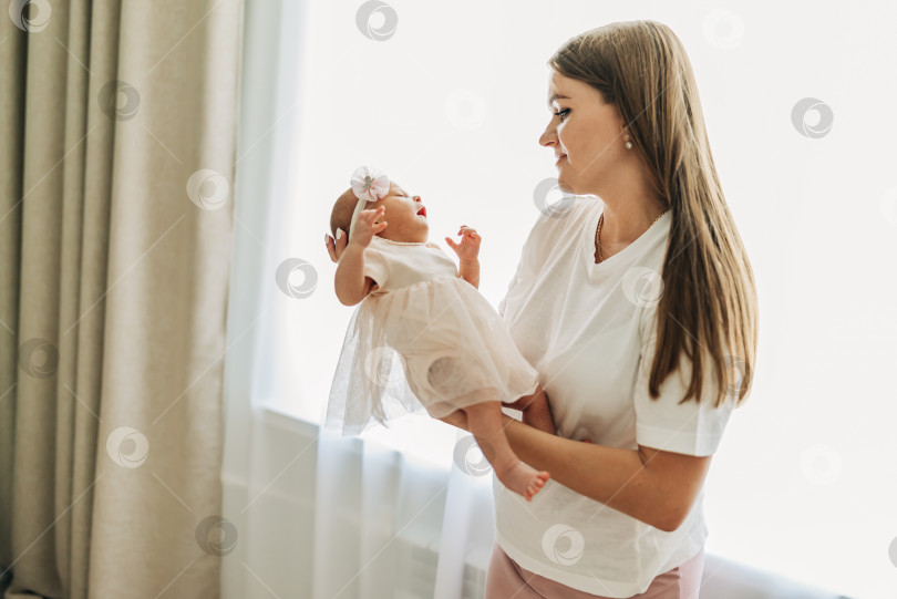 Скачать Мама со своим малышом новорожденный младенец малыш ребенок дома ухаживает в спальне, надевает одежду. Женщина семья женское здоровье и материнство фотосток Ozero
