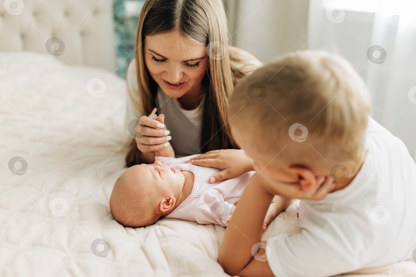 Скачать Семейный портрет родителей с новорожденным ребенком и старшим сыном. Счастье и любовь дома в закрытом помещении фотосток Ozero