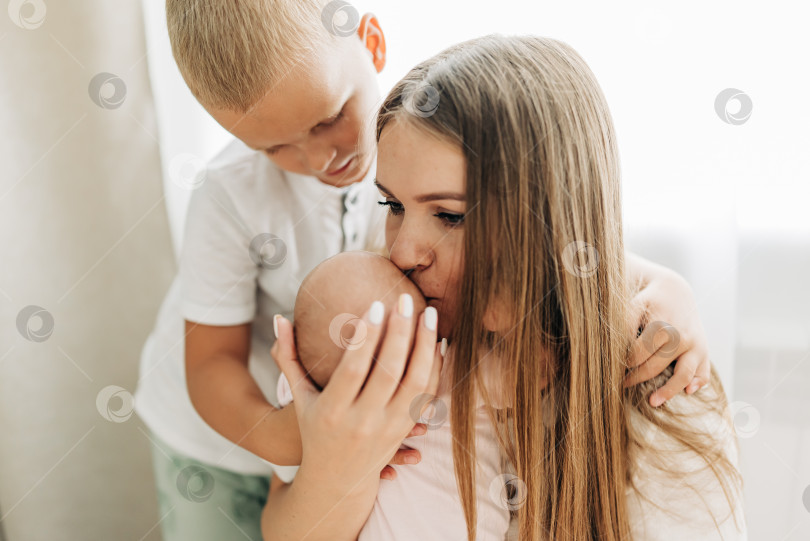 Скачать Семейный портрет родителей с новорожденным ребенком и старшим сыном. Счастье и любовь дома в закрытом помещении фотосток Ozero