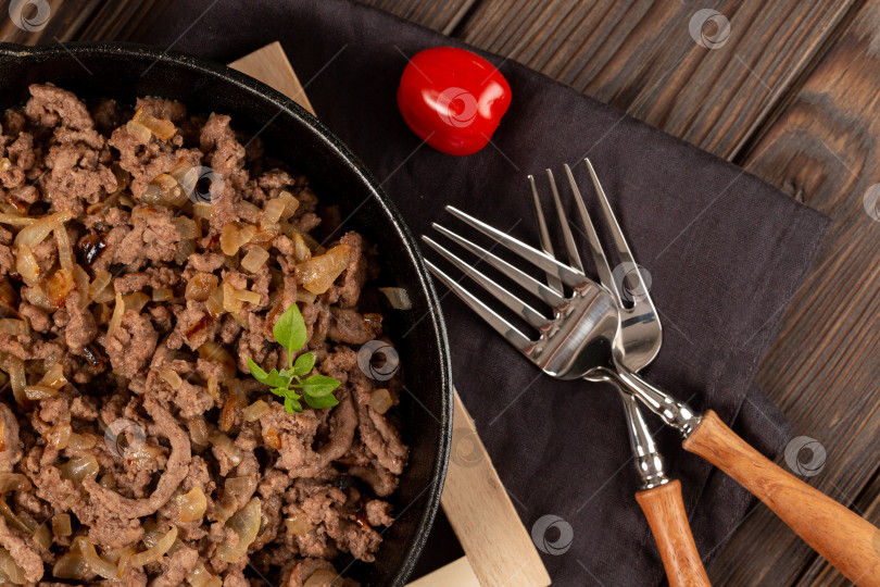 Скачать Мясной фарш, обжаренный с луком и специями в чугунной сковороде фотосток Ozero