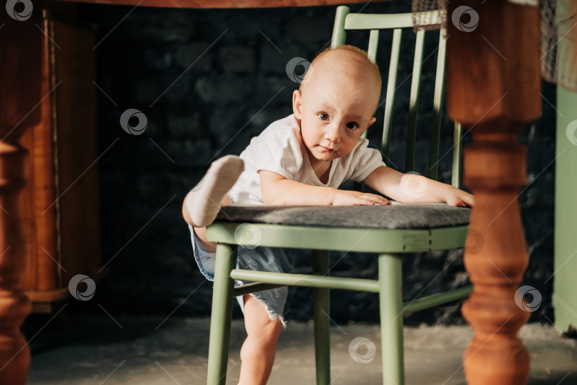 Скачать Маленькая девочка взбирается на высокий стул ребенок взбирается на стул фотосток Ozero