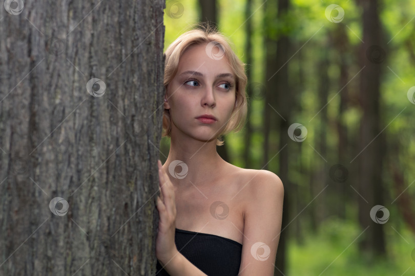 Скачать красивая девушка рядом с деревом на размытом фоне леса фотосток Ozero