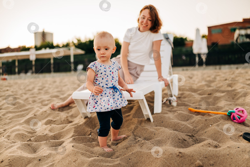 Скачать Ребенок и мама играют вместе на открытом воздухе. Маленький ребенок на поднятых руках мамы, они вместе играют в городском парке. Счастливая семья летом на свежем воздухе. Мать и ребенок прогуливаются по пляжу. фотосток Ozero