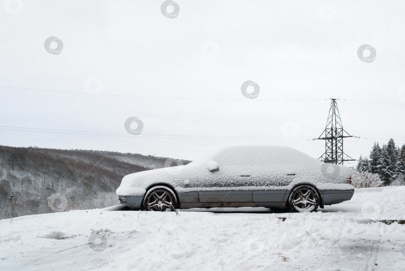 Скачать Заснеженная машина. Снежный сугроб сверху на автомобиле на открытом воздухе фотосток Ozero