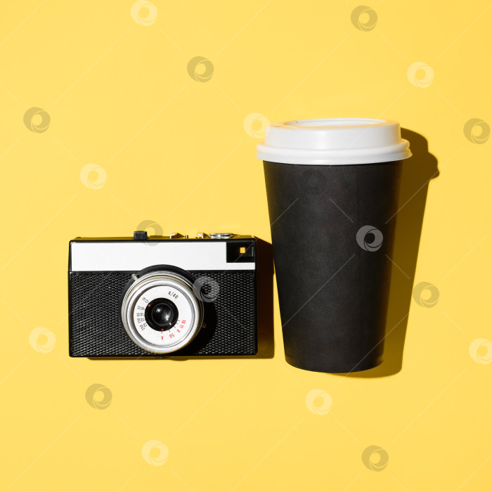 Скачать Ретро-пленочная камера и одноразовая чашка кофе крупным планом. Желтый фон, ровная поверхность фотосток Ozero