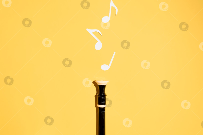 Скачать Музыкальная флейта и ноты, плоско лежащие на желтом фоне. Пространство для копирования фотосток Ozero