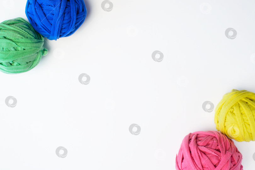 Скачать Цветные тряпичные шарики, плоско лежащие на белом фоне. Переработанный материал для вязания одеял, место для копирования. фотосток Ozero