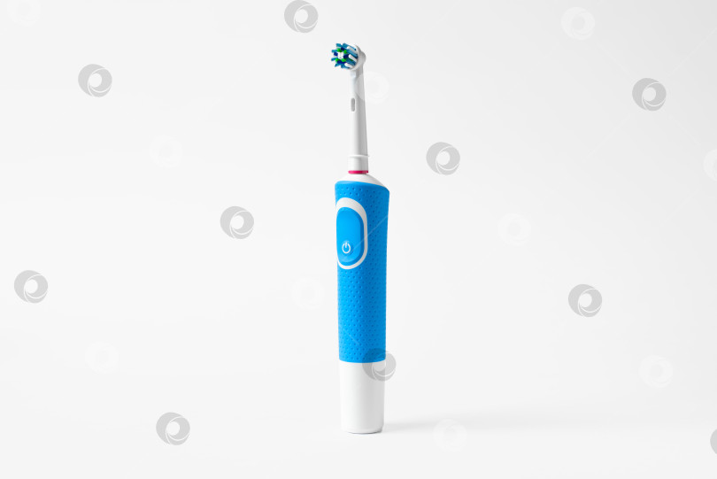 Скачать Современная электрическая зубная щетка, стоящая на белом фоне. Контролируемое средство для ежедневного ухода за полостью рта. фотосток Ozero