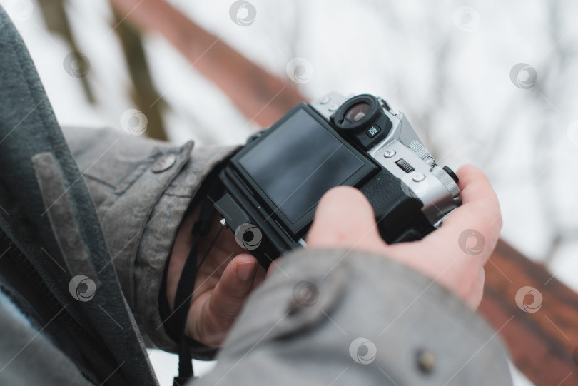 Скачать Крупный план мужчины, пользующегося камерой. Фотограф на улице зимой. Избирательный фокус фотосток Ozero