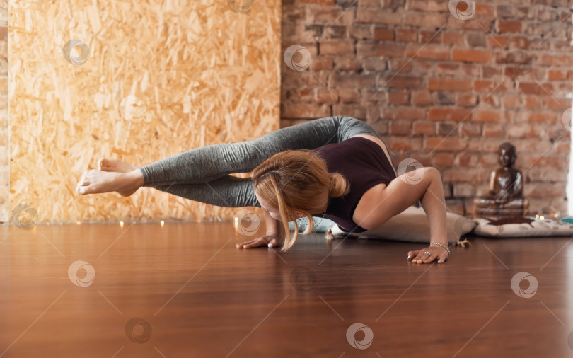Скачать Молодая женщина занимается йогой в светлом тренажерном зале. Поза восьми углов, аштаваркасана. Спортивный образ жизни. фотосток Ozero