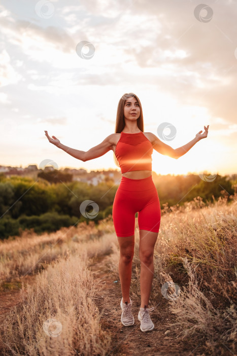 Скачать Фитнес-женщина, готовая к пробежке на закате или восходе солнца по пляжу. Спортсменка в мощной позе на стартовой линии. фотосток Ozero