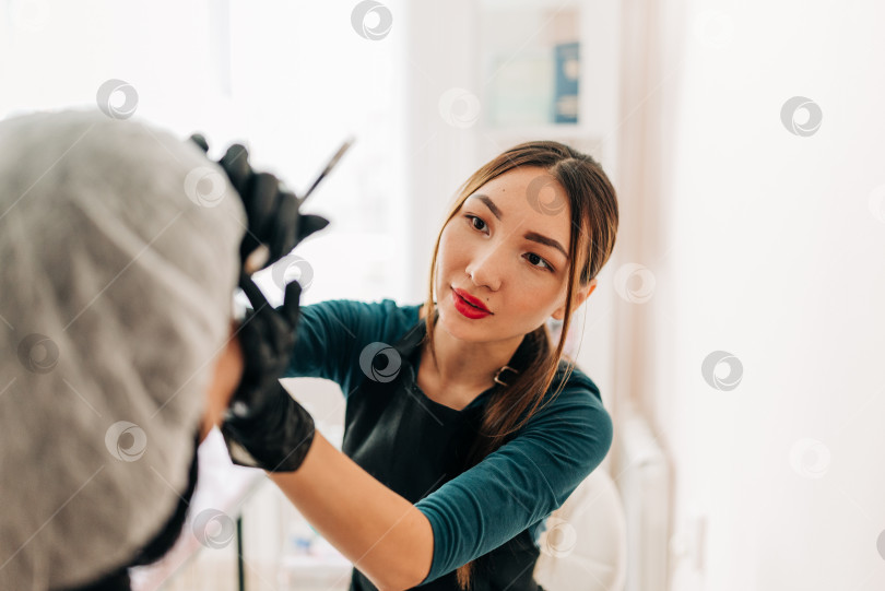Скачать Перманентный макияж на лице, женщина с татуировкой века в салоне красоты фотосток Ozero