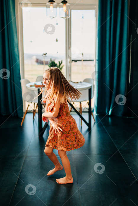 Скачать Забавный очаровательный счастливый ребенок девочка прыгает дома в помещении, милый маленький ребенок весело танцует под музыку, играющую в помещении в одиночестве наслаждайтесь притворяясь танцором утром фотосток Ozero