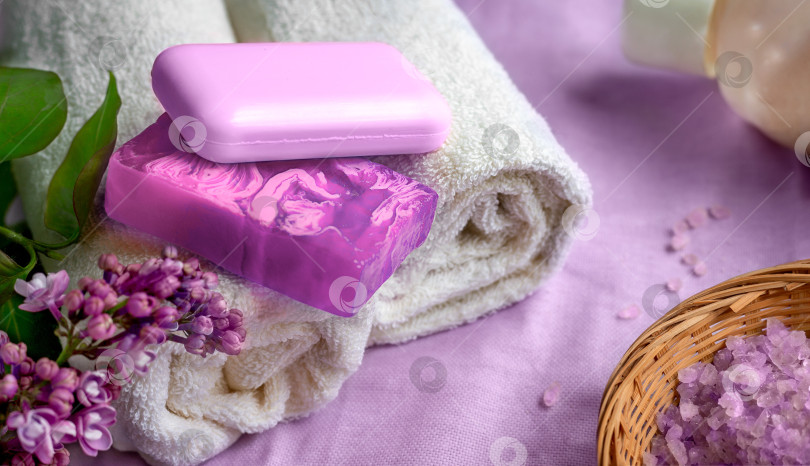 Скачать Спа-принадлежности и банные принадлежности в фиолетовых тонах. Мыло, полотенца, морская соль. Ветка сирени. фотосток Ozero