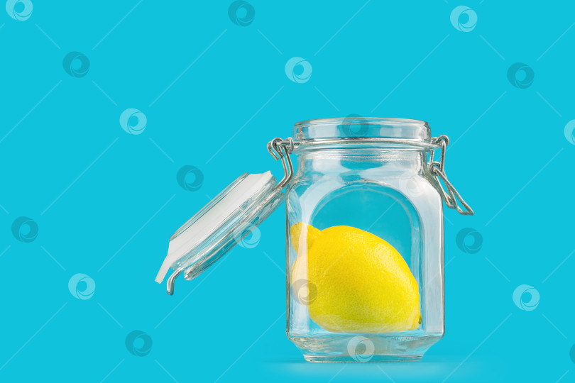 Скачать Стеклянная банка с лимоном, изолят на синем фоне фотосток Ozero