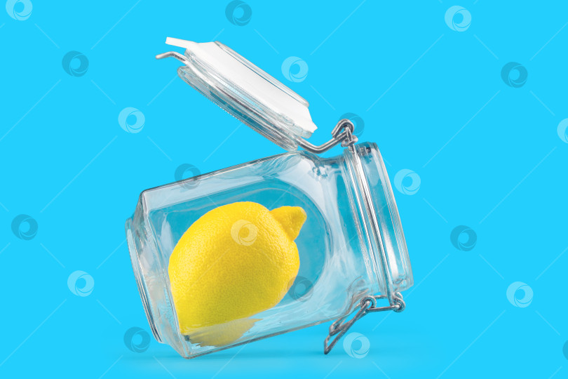 Скачать Стеклянная банка с лимоном, изолят на синем фоне фотосток Ozero