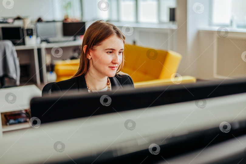 Скачать Молодая женщина в офисе работает на компьютере. Сотрудница женского пола фотосток Ozero