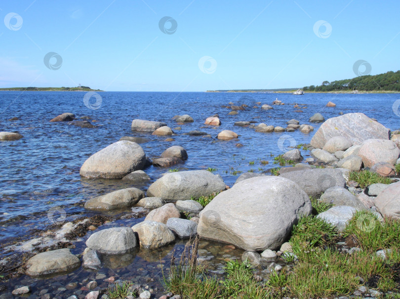 Скачать Большие валуны на берегу Северного моря. Пейзаж скалистого пляжа в теплый солнечный день. фотосток Ozero