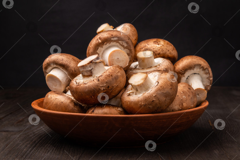 Скачать грибы в глиняной миске на столе из темного дерева фотосток Ozero