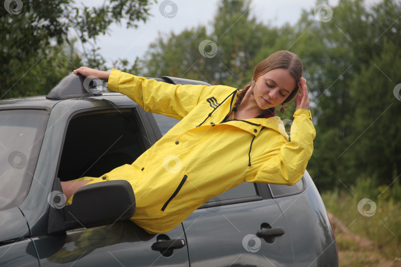 Привлекательная женщина позирует за рулем своей машины