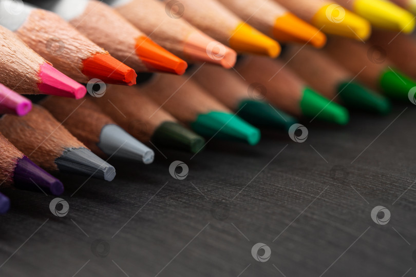 Скачать заточенные цветные карандаши в серебристой рубашке на черном бумажном фоне фотосток Ozero