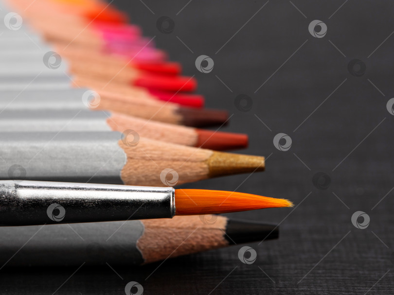 Скачать заточенные цветные карандаши в серебристой рубашке на черном бумажном фоне фотосток Ozero