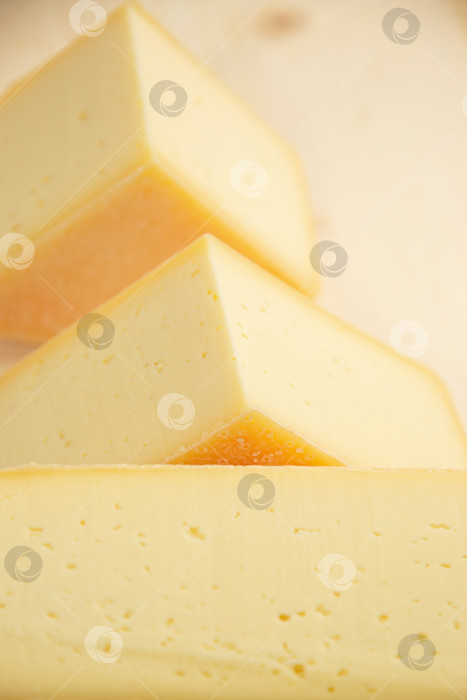 Скачать сыр разных сортов на натуральном деревянном фоне, цельный и нарезанный фотосток Ozero