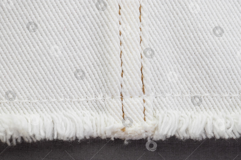 Скачать белая джинсовая ткань, соединяющая детали различными швами коричневыми нитками фотосток Ozero