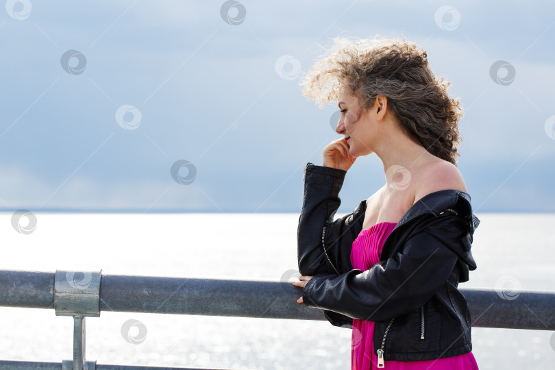 Скачать Женщина стоит на мосту на фоне хмурого неба фотосток Ozero