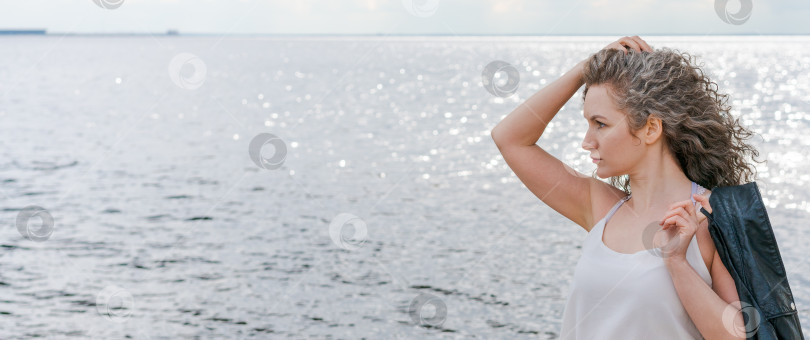 Скачать Привлекательная женщина наслаждается летними прогулками по набережной. Носит футболку фотосток Ozero