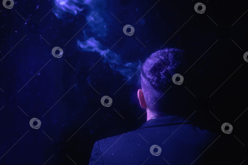 Скачать Мужчина стоит спиной к камере и курит фотосток Ozero